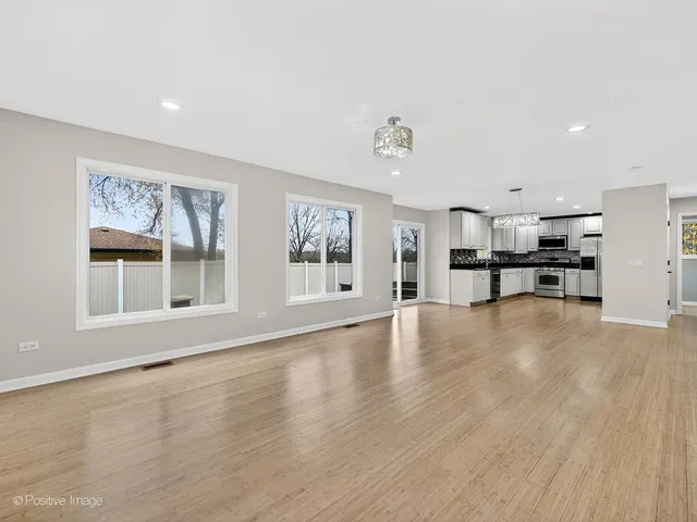 a view of empty room with wooden floor and windows