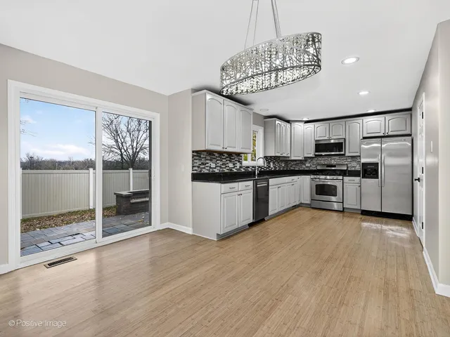 a kitchen with stainless steel appliances granite countertop a stove top oven a sink and cabinets