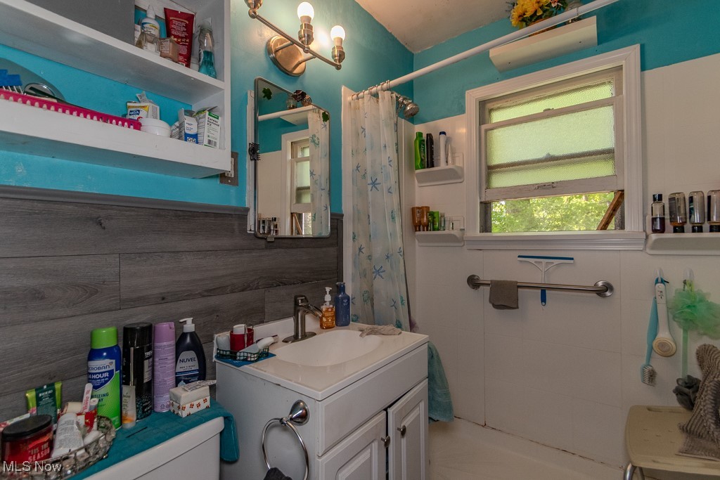 Full bathroom with toilet, a shower with shower curtain, and vanity
