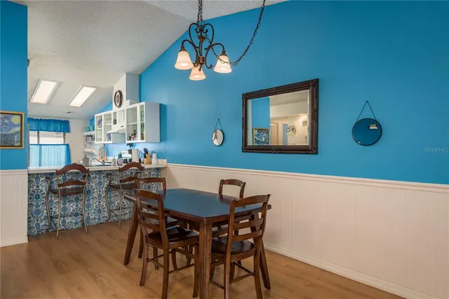 a view of a dining room with furniture a chandelier and wooden floor