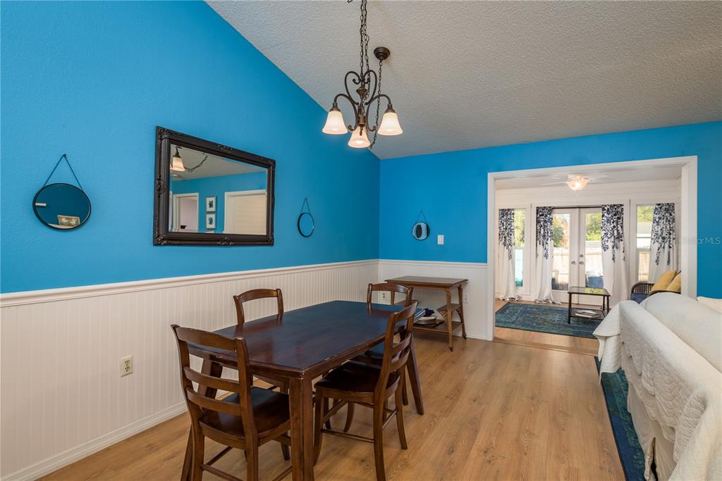 102 Anclote Road Tarpon Springs, FL 34689 - Photo 14 of 42 a view of a dining room with furniture a chandelier and wooden floor
