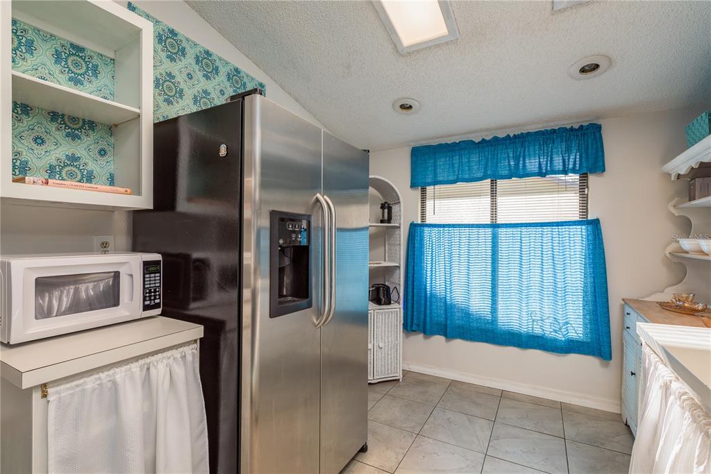 102 Anclote Road Tarpon Springs, FL 34689 - Photo 18 of 42 a kitchen with a refrigerator a oven and wooden cabinets