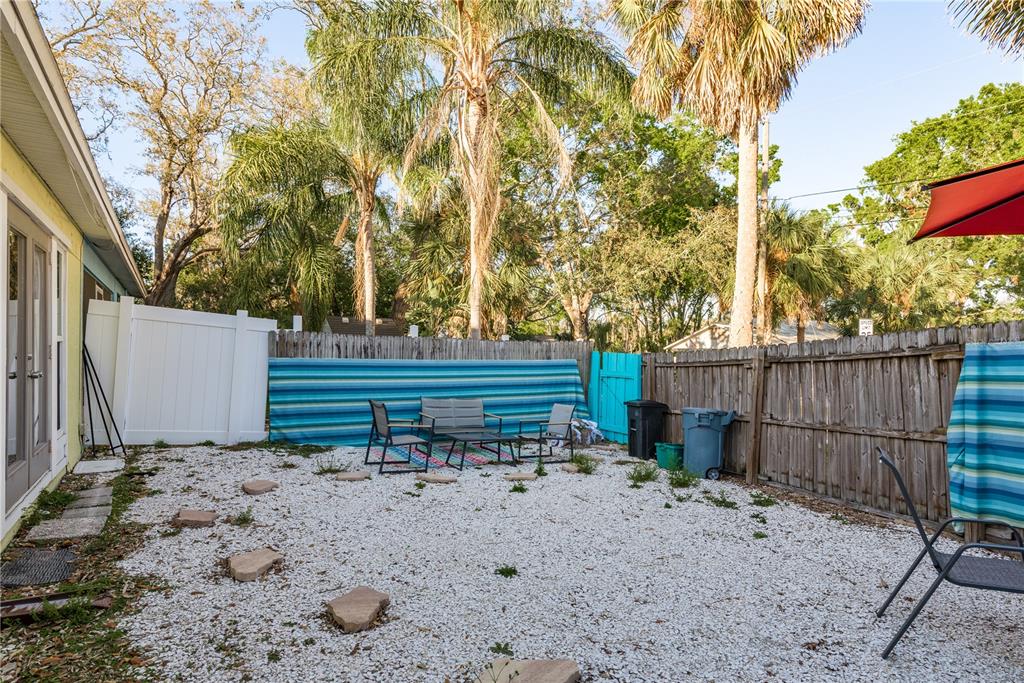 102 Anclote Road Tarpon Springs, FL 34689 - Photo 29 of 42 a backyard of a house with barbeque oven table and chairs
