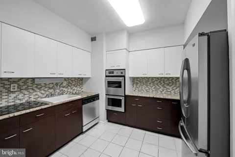 a kitchen with stainless steel appliances granite countertop a refrigerator and a sink