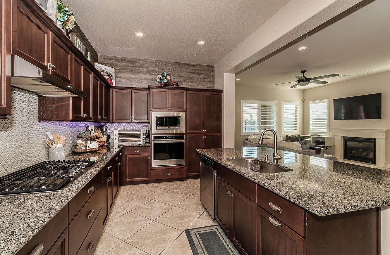 a kitchen with stainless steel appliances granite countertop a sink stove and refrigerator