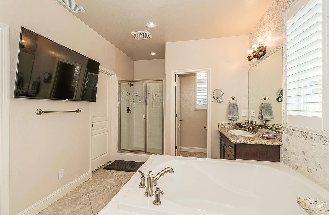 1035 Agua Dulce Avenue Clovis, CA 93619 - Photo 18 of 40 a spacious bathroom with a tub sink and mirror
