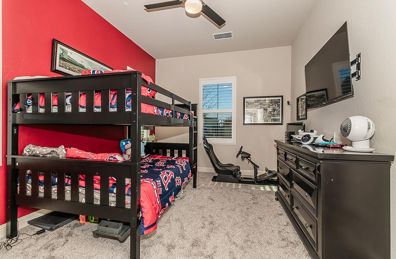 1035 Agua Dulce Avenue Clovis, CA 93619 - Photo 22 of 40 a bedroom with furniture a flat screen tv and a window