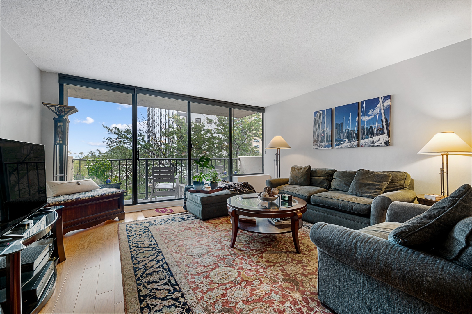 3150 North Sheridan Road, Unit 3C Chicago, IL 60657 - Photo 3 of 19 a living room with furniture a flat screen tv and a floor to ceiling window