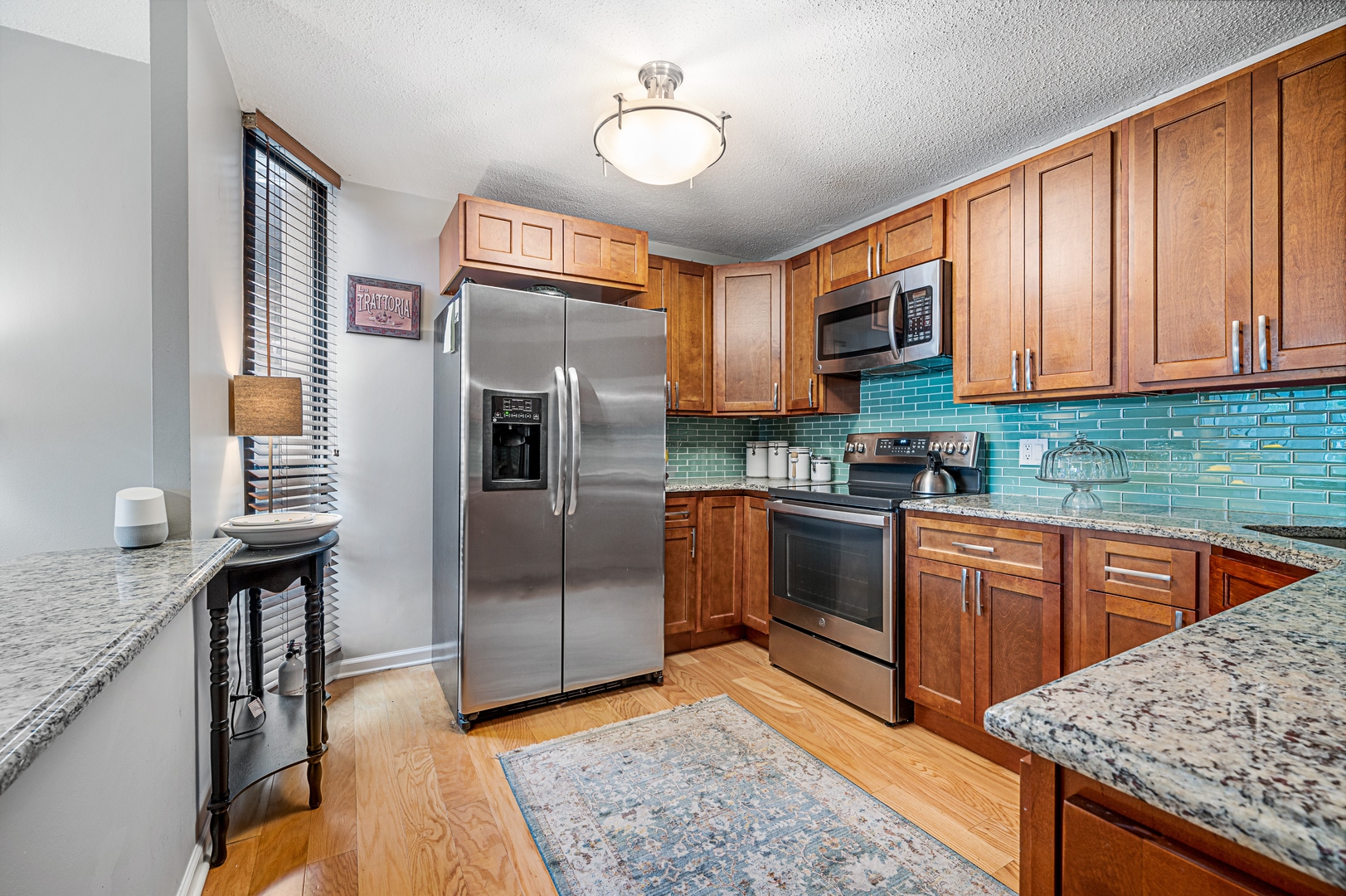 3150 North Sheridan Road, Unit 3C Chicago, IL 60657 - Photo 6 of 19 a kitchen with stainless steel appliances granite countertop a refrigerator a sink dishwasher a stove and white countertops with wooden floor