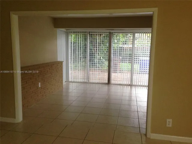 a view of a livingroom with a floor to ceiling window and carpet