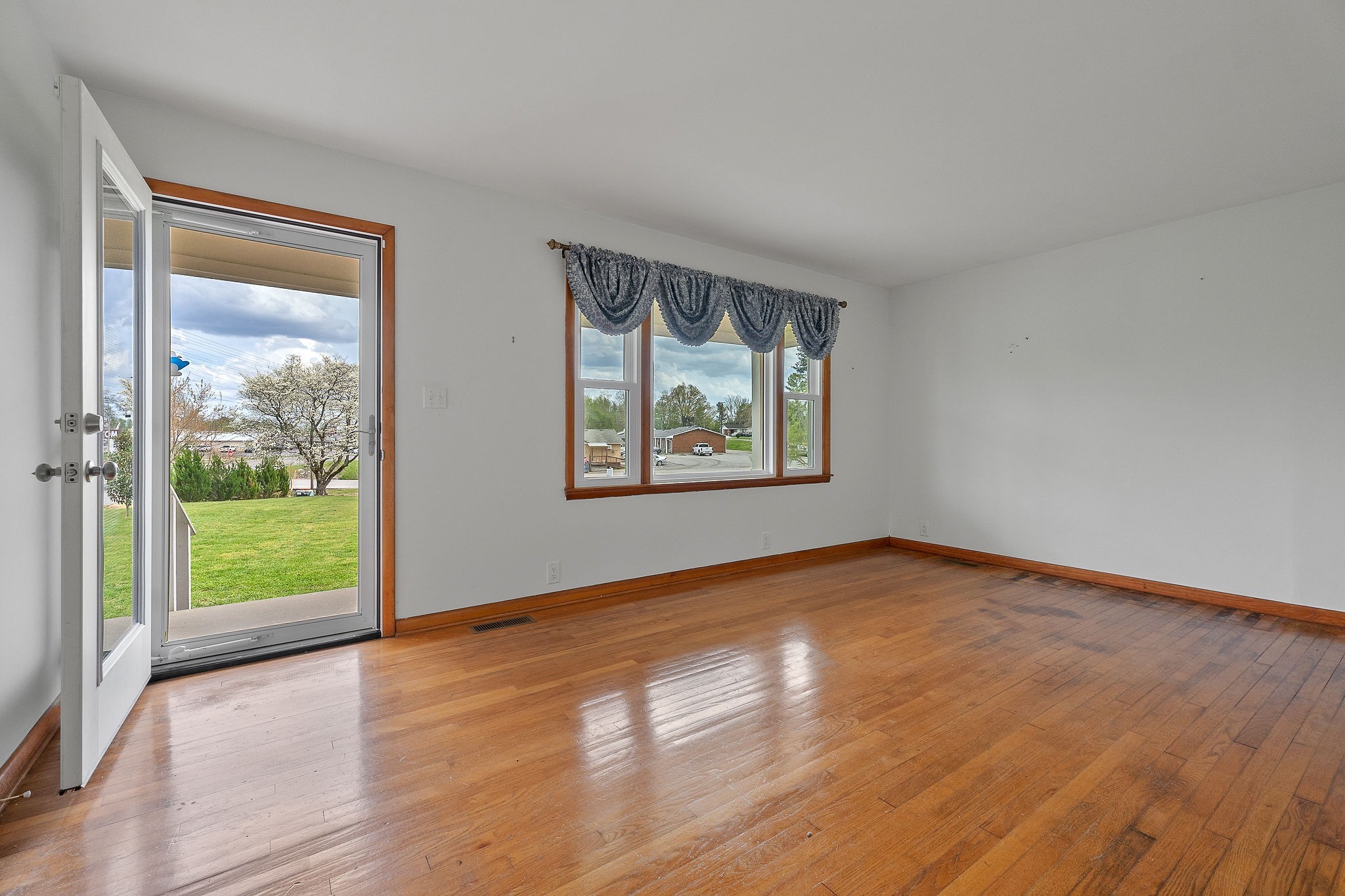 401 Whaley Street Smithville, TN 37166 - Photo 7 of 37 a view of an empty room with wooden floor and a window