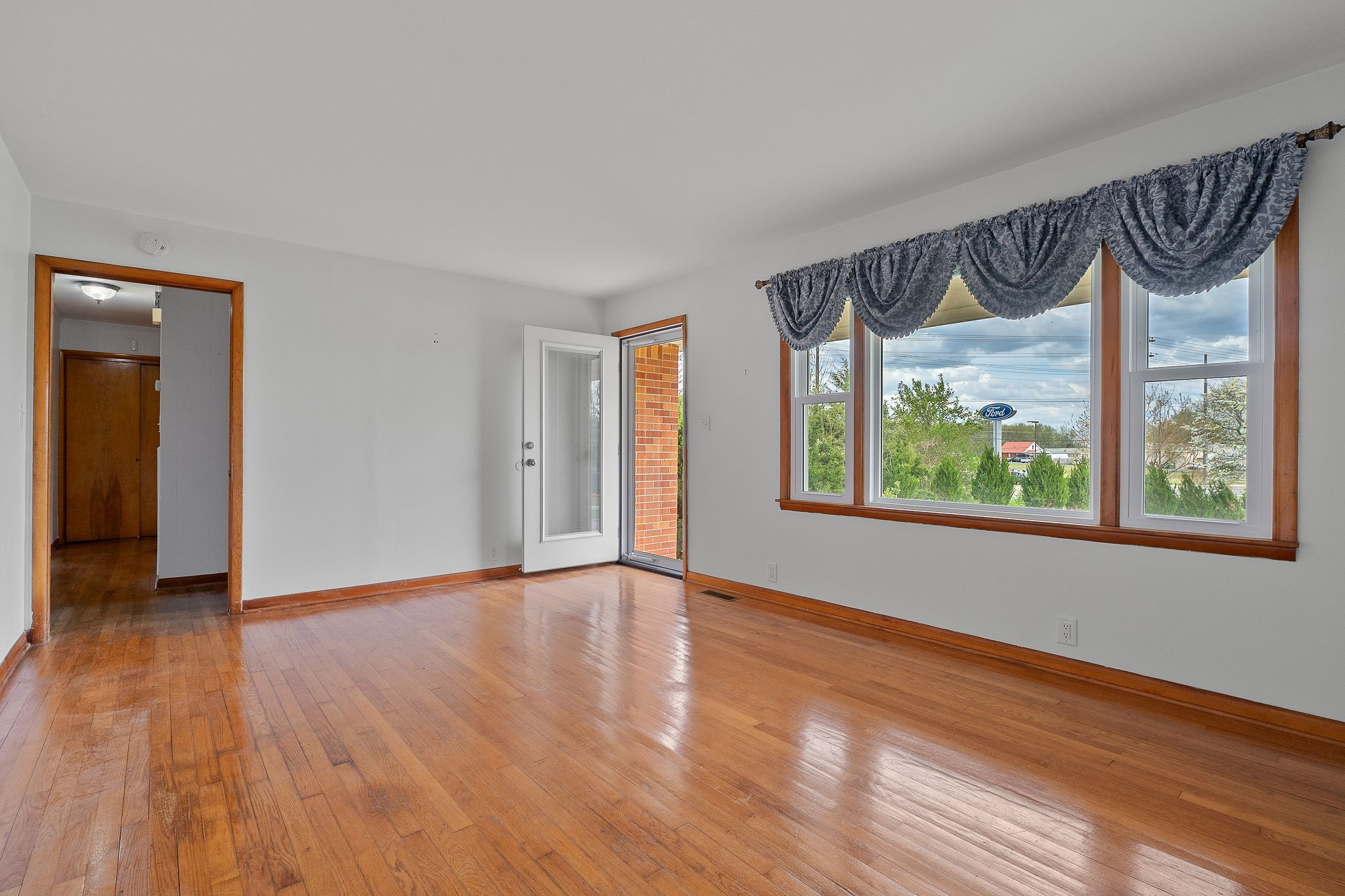 401 Whaley Street Smithville, TN 37166 - Photo 9 of 37 a view of an empty room with a window and wooden floor