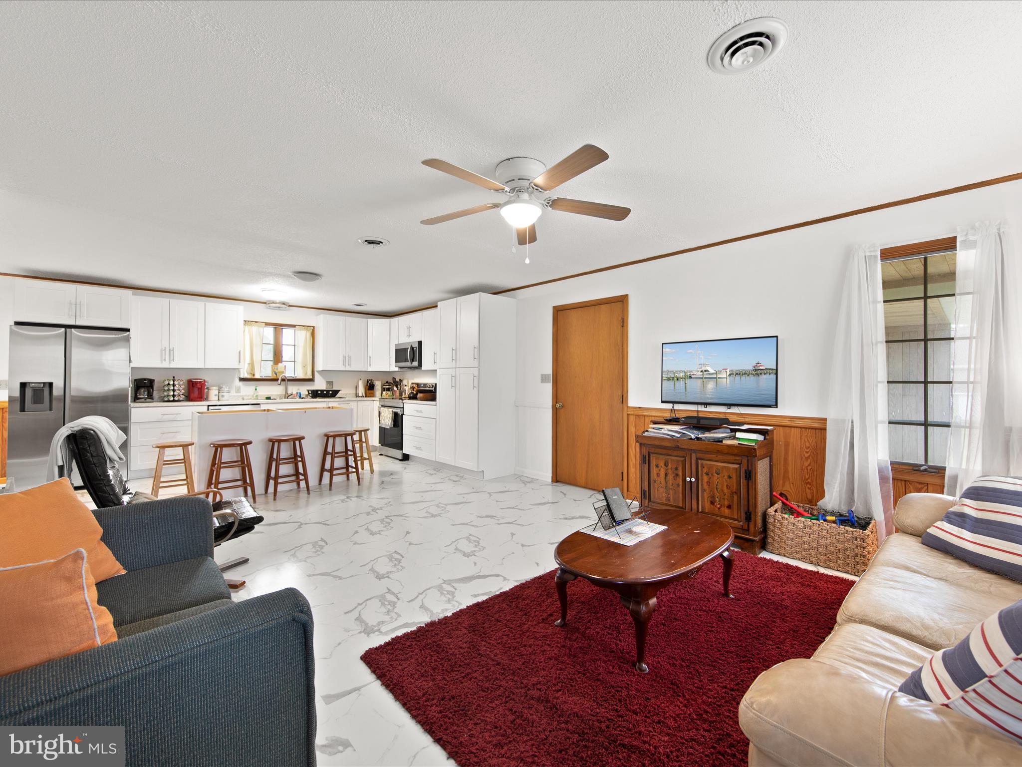 23451 Deal Island Road Deal Island, MD 21821 - Photo 15 of 49 a living room with furniture a table and a flat screen tv
