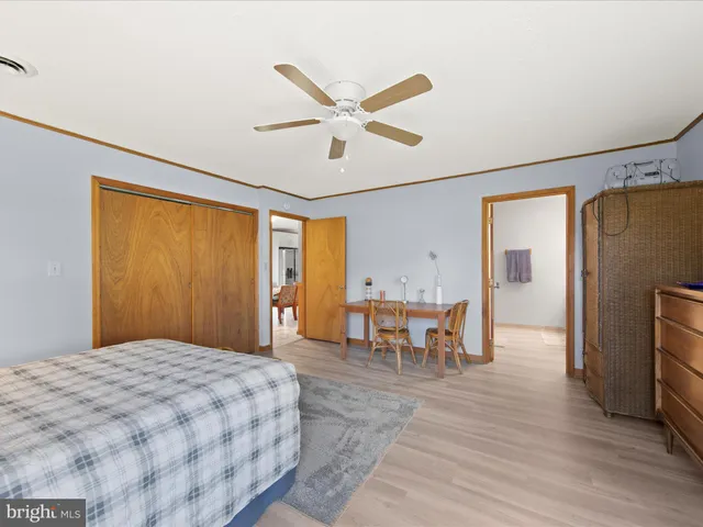 a bedroom with a bed and a table with wooden floor