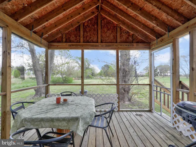 a view of a porch with furniture and wooden floor