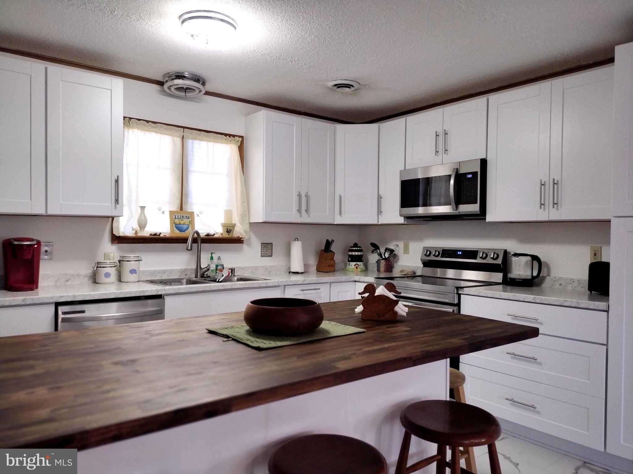 23451 Deal Island Road Deal Island, MD 21821 - Photo 10 of 49 a kitchen with sink a stove and cabinets