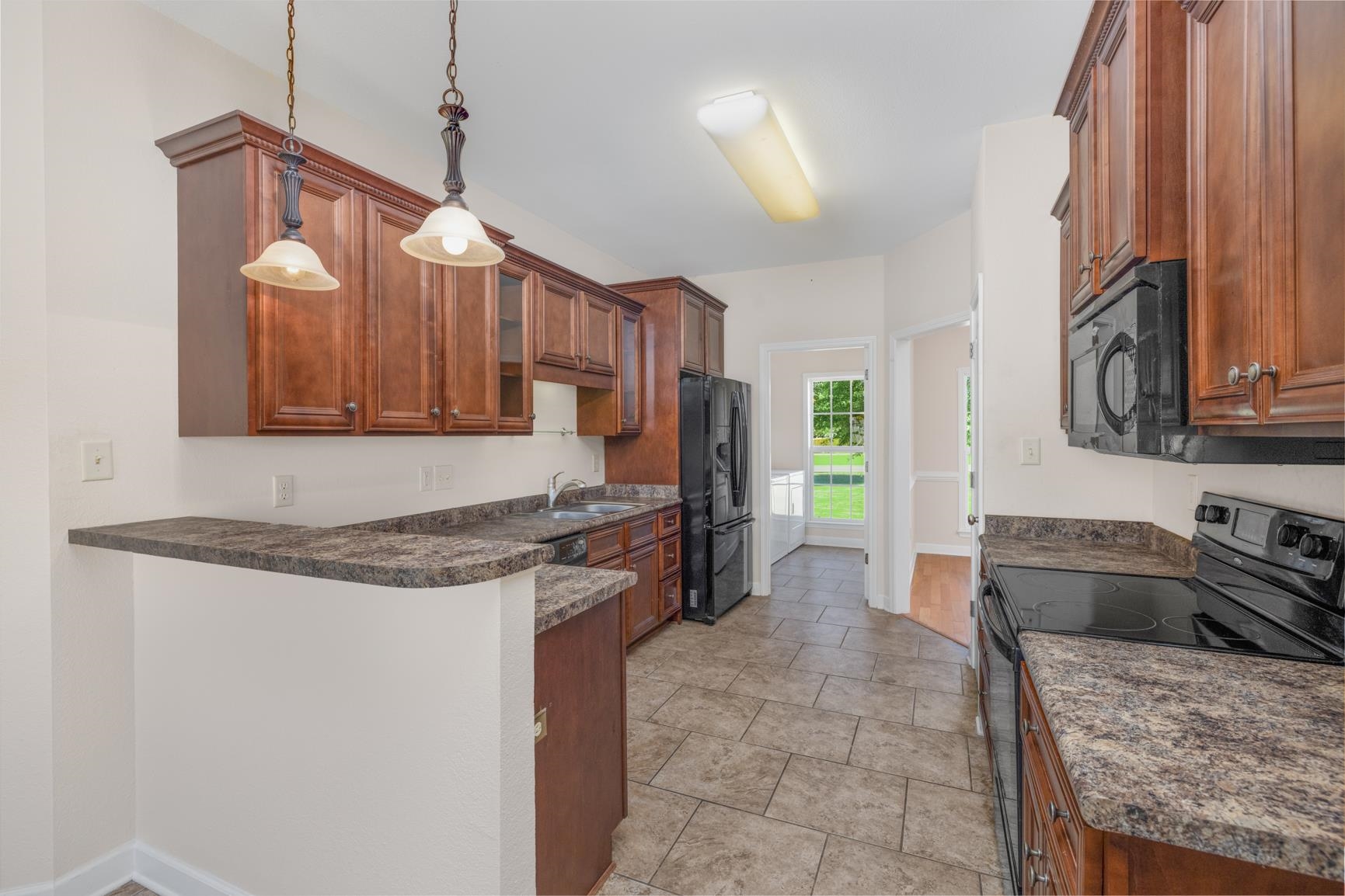 251 Rosemark Road Atoka, TN 38004 - Photo 11 of 40 Kitchen featuring sink, black appliances, kitchen peninsula, and pendant lighting