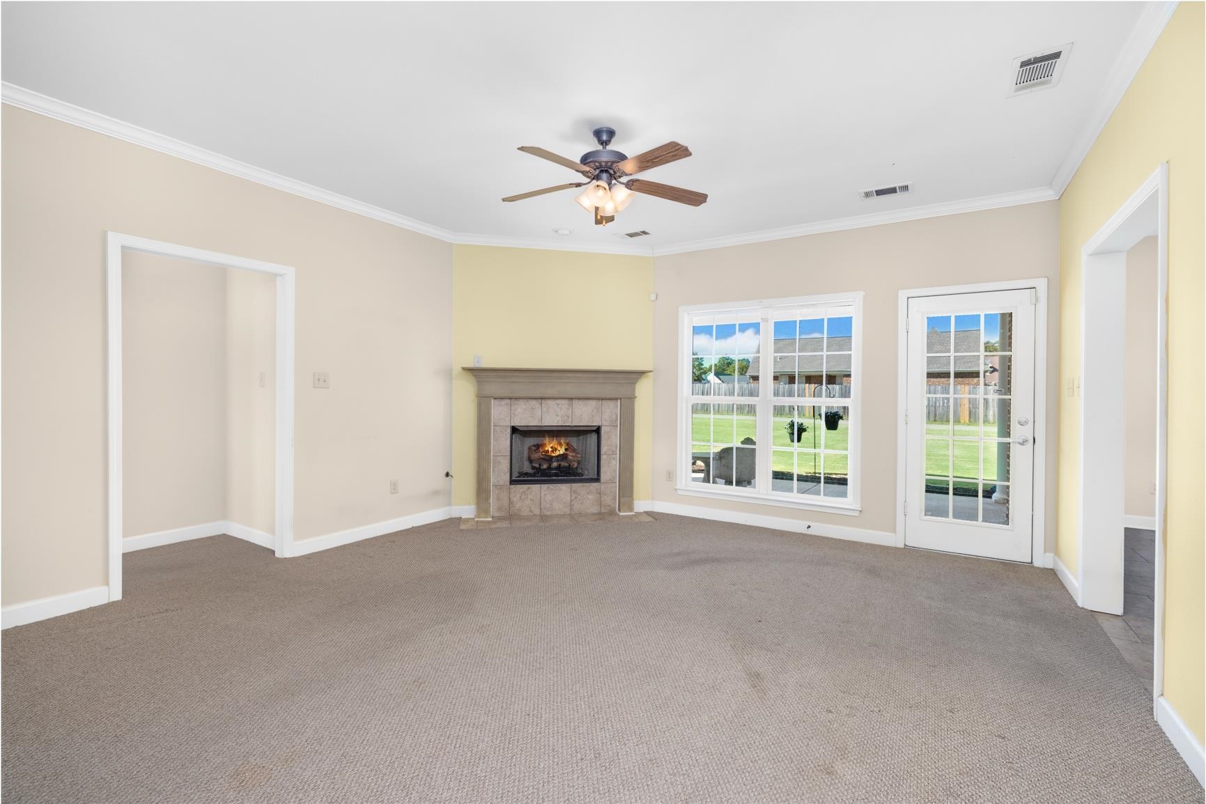 251 Rosemark Road Atoka, TN 38004 - Photo 18 of 40 Unfurnished living room with ornamental molding, carpet, a tile fireplace, and ceiling fan