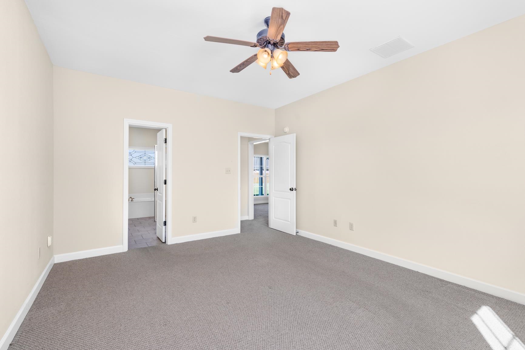 251 Rosemark Road Atoka, TN 38004 - Photo 21 of 40 Unfurnished bedroom with a spacious closet, carpet, and ceiling fan