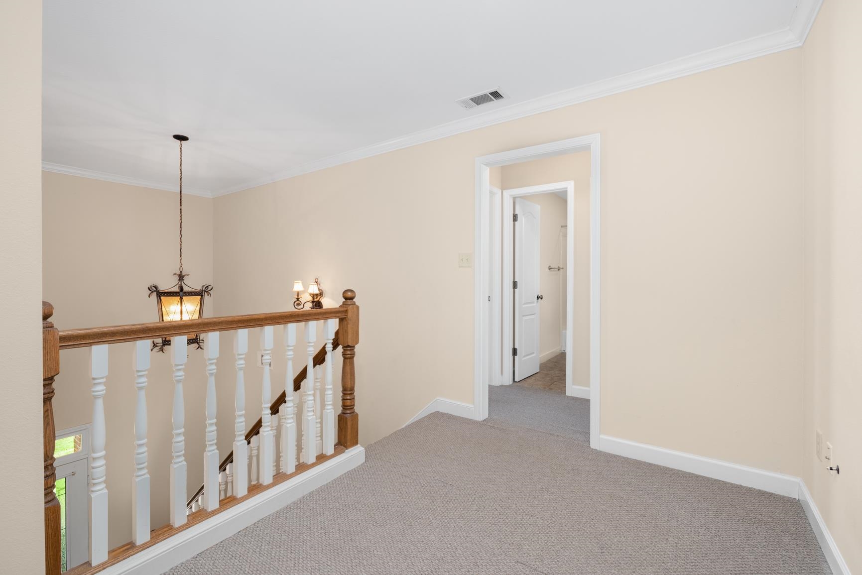 251 Rosemark Road Atoka, TN 38004 - Photo 25 of 40 Hallway with ornamental molding, a chandelier, and carpet