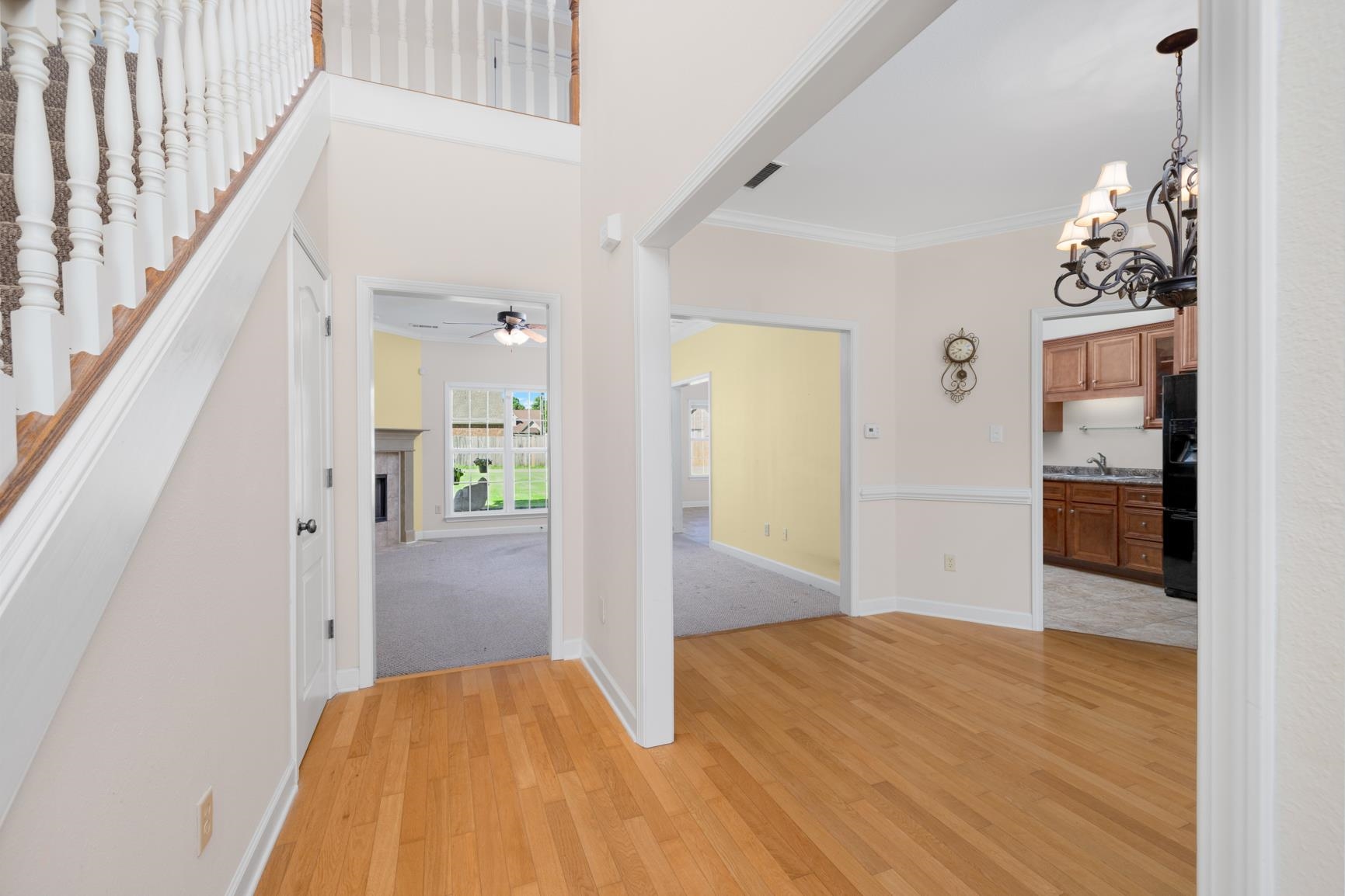 251 Rosemark Road Atoka, TN 38004 - Photo 4 of 40 Hallway with crown molding, light hardwood flooring, and an inviting chandelier