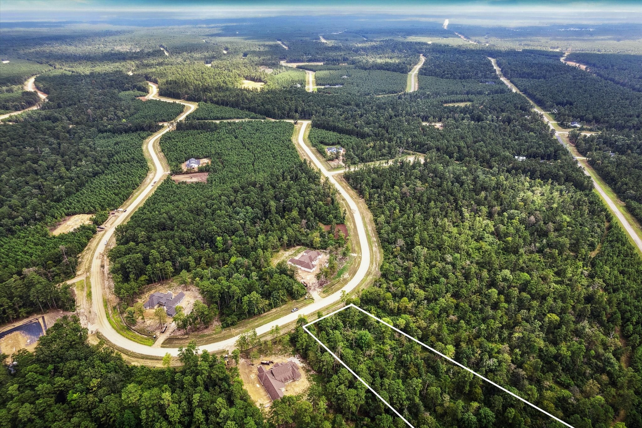 an aerial view of a house with a yard and lake view