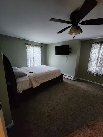 a bedroom with a bed tv and window