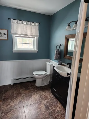a spacious bathroom with a toilet sink and mirror