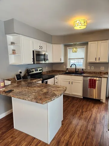 a kitchen with stainless steel appliances granite countertop a sink a stove and cabinets