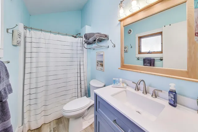 a bathroom with a toilet sink vanity and mirror