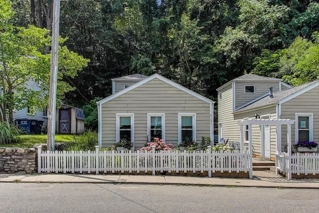 a view of a house with a yard and large trees