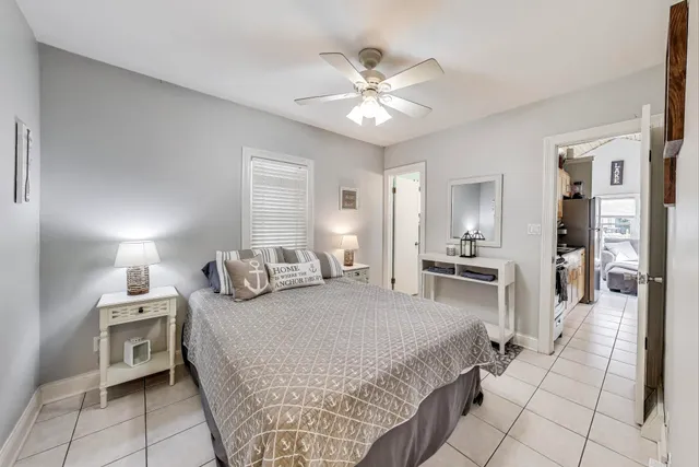 a spacious bedroom with a bed a chandelier and flat screen tv