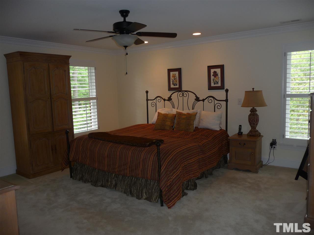 4733 Sharpstone Lane Raleigh, NC 27615 - Photo 9 of 23 a bedroom with a bed and a chandelier