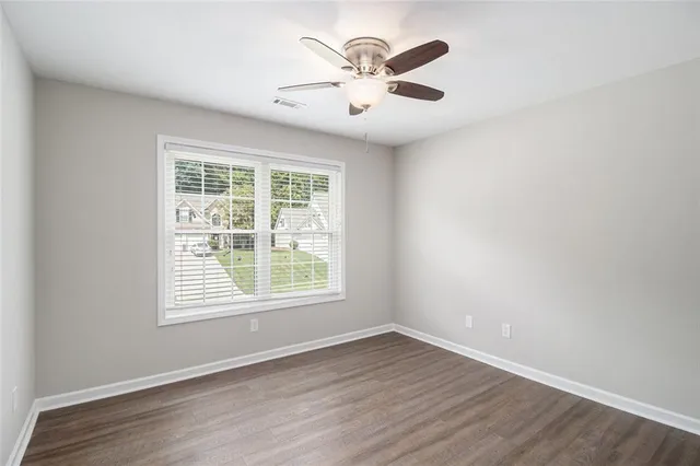 an empty room with wooden floor and windows