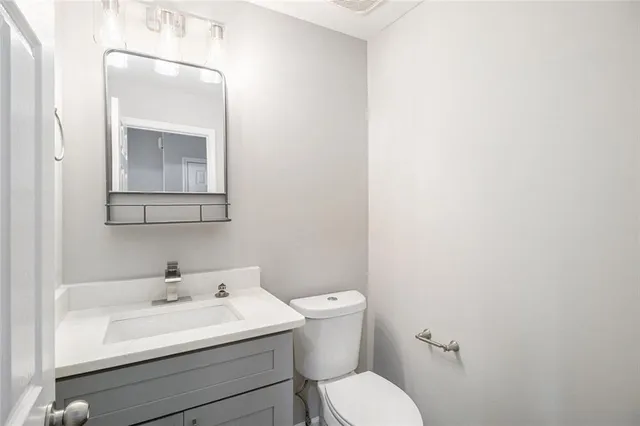 a bathroom with a toilet sink and mirror