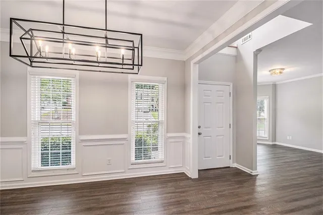 a view of empty room with wooden floor and windows