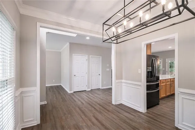 a view of a hallway with wooden floor and cabinets