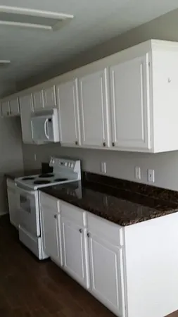 a kitchen with granite countertop white cabinets and a sink