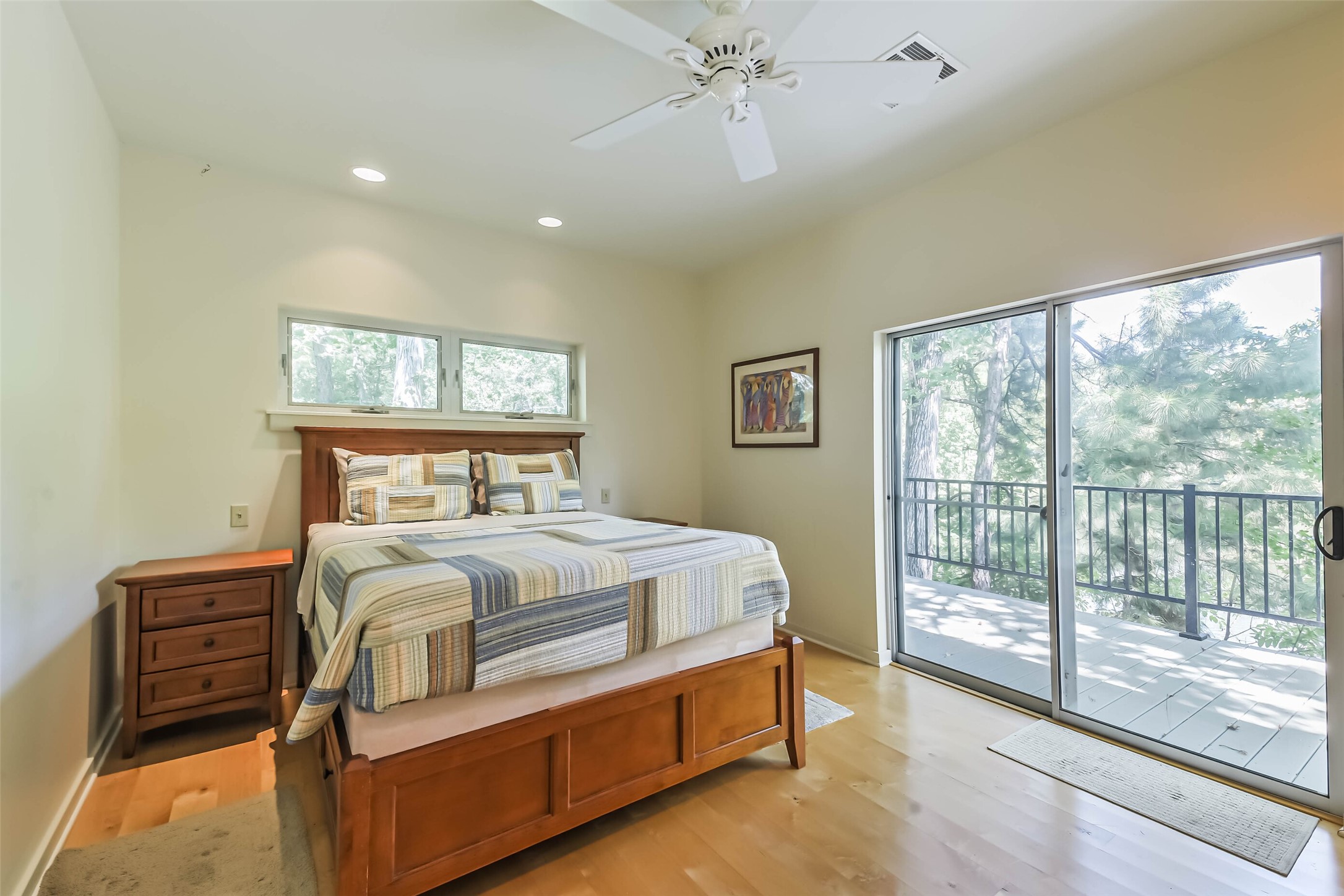 88 Raccoon Ramble Cleveland, TX 77327 - Photo 24 of 43 Bright and inviting bedroom with a cozy bed, hardwood floors, and large sliding glass doors leading to a private balcony with serene views.