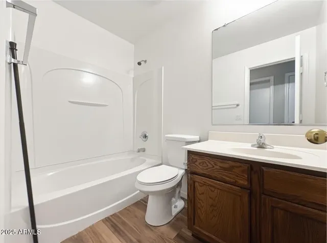 a bathroom with a bathtub shower sink vanity mirror and toilet