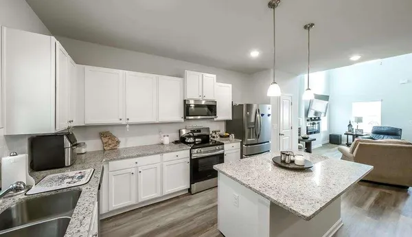 a kitchen with a stove a sink a refrigerator and cabinets