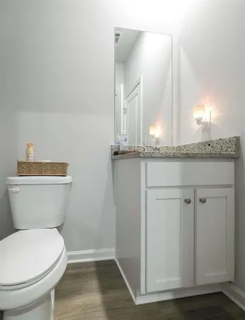 a bathroom with a granite countertop sink and a toilet