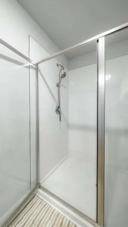 a bathroom with a shower sink and mirror