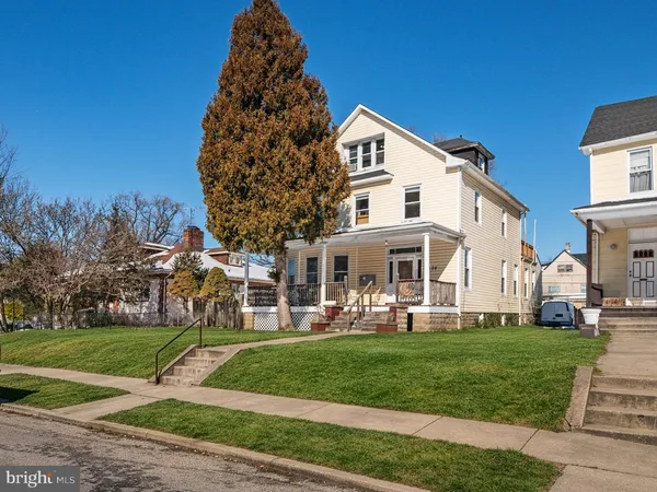 a view of a white house with a yard table and chairs