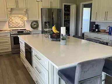 a kitchen with stainless steel appliances a stove a sink and a refrigerator