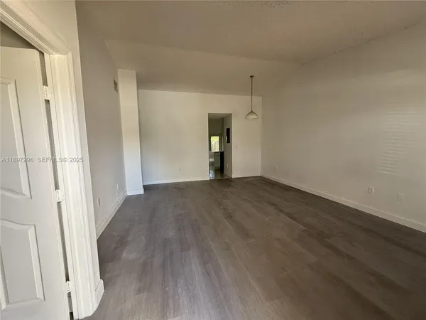 a view of empty room with wooden floor