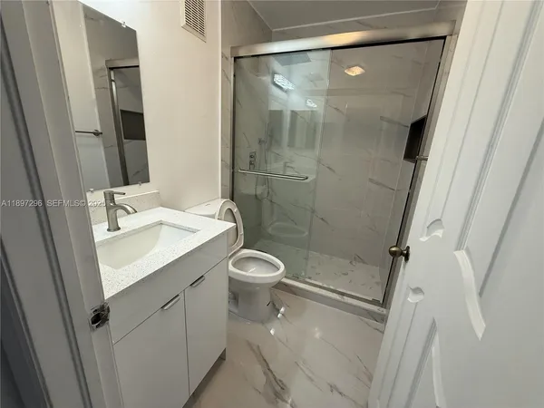 a bathroom with a shower sink vanity and mirror