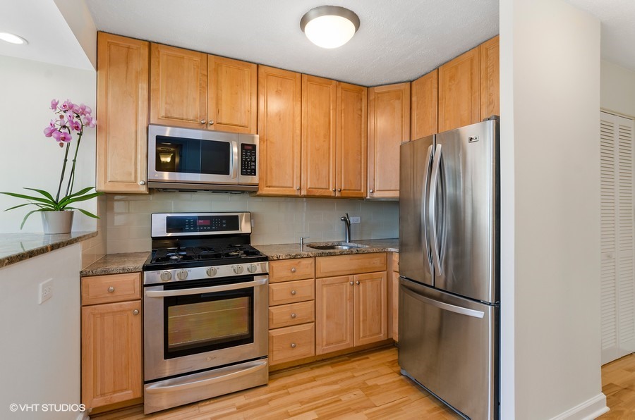 1 East Scott Street, Unit 2307 Chicago, IL 60610 - Photo 7 of 14 a kitchen with stainless steel appliances a stove microwave and refrigerator