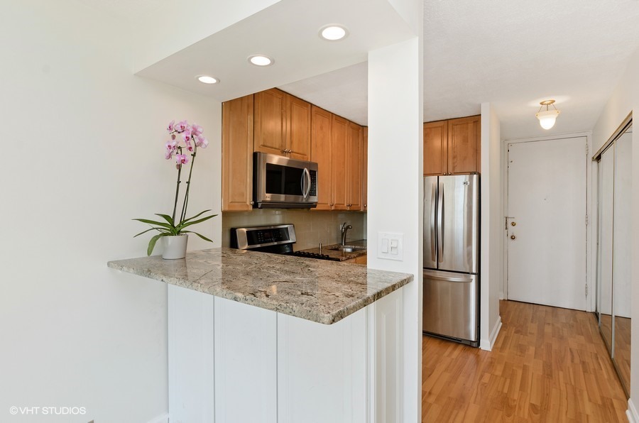 1 East Scott Street, Unit 2307 Chicago, IL 60610 - Photo 8 of 14 a kitchen with stainless steel appliances granite countertop a refrigerator and a sink