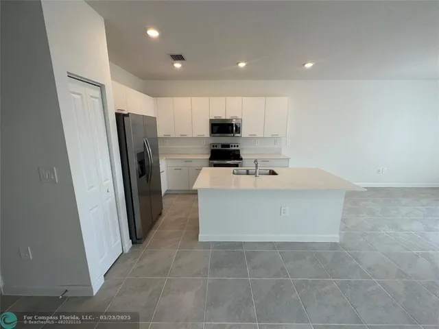 a kitchen with stainless steel appliances a refrigerator sink and microwave
